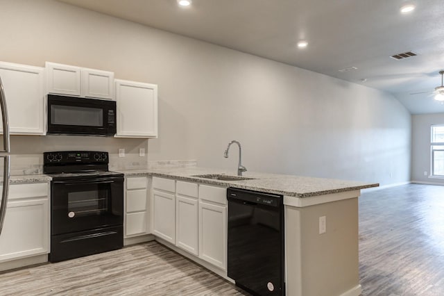 kitchen featuring sink, kitchen peninsula, white cabinets, and black appliances