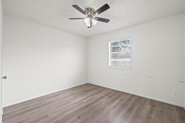 empty room featuring ceiling fan, hardwood / wood-style floors, and a textured ceiling