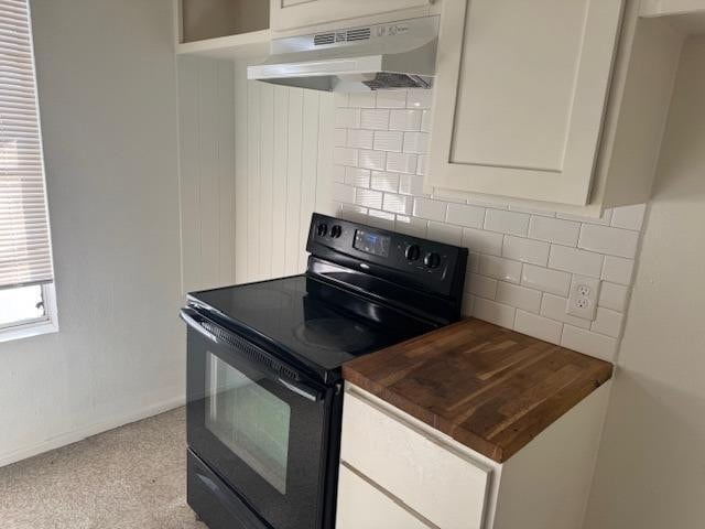 kitchen featuring white cabinets, black electric range, and backsplash