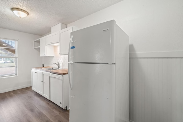 kitchen featuring sink, white appliances, white cabinetry, light hardwood / wood-style floors, and a textured ceiling