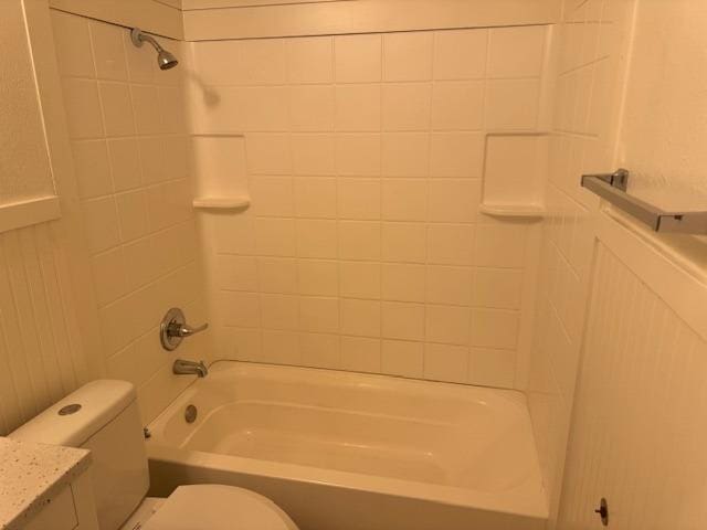 full bathroom with tiled shower / bath, vanity, and toilet