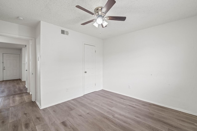 unfurnished bedroom featuring ceiling fan, a textured ceiling, and light wood-type flooring