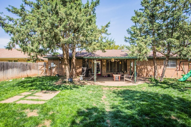 back of property featuring fence, a yard, ceiling fan, a patio, and brick siding