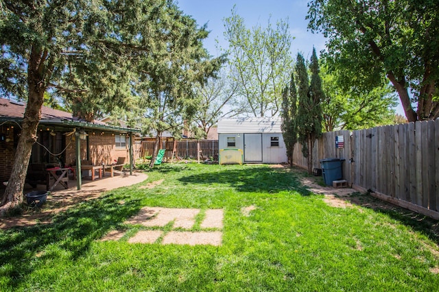 view of yard featuring a playground, a fenced backyard, a storage shed, a patio area, and an outbuilding