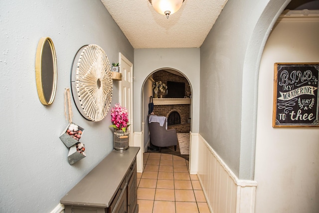 hallway featuring a textured ceiling and light tile patterned floors