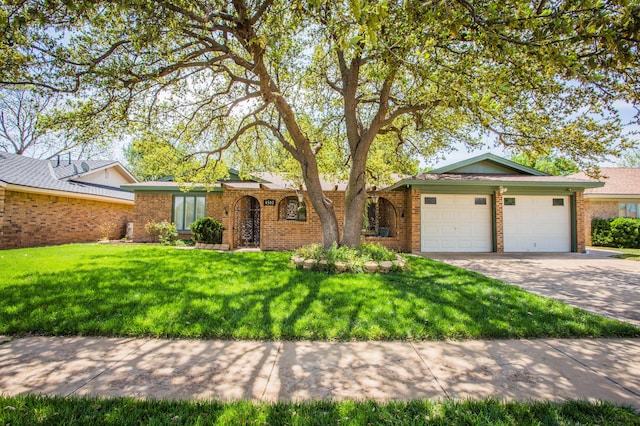 ranch-style house featuring an attached garage, driveway, brick siding, and a front yard