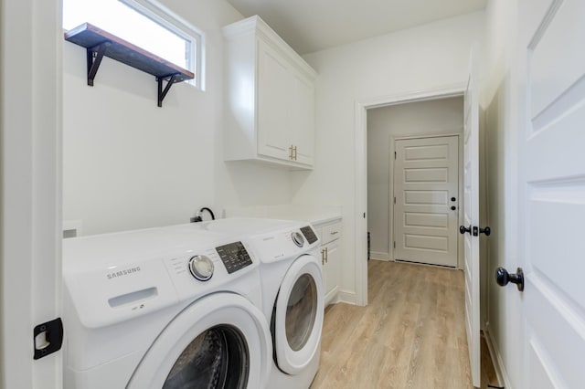 laundry room featuring cabinets, washing machine and dryer, and light wood-type flooring