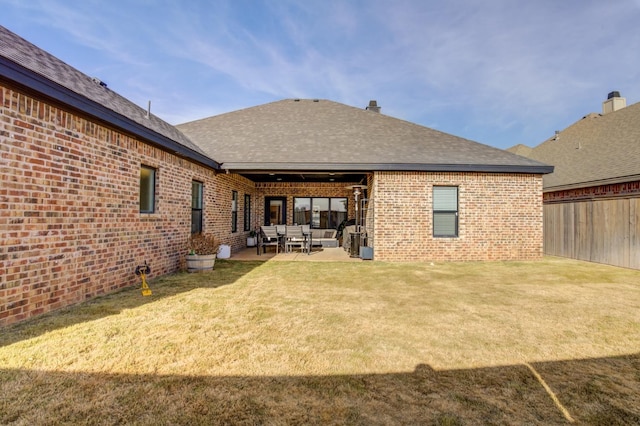 back of property with a yard and a patio area