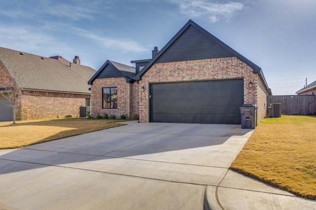 view of front facade featuring a garage, a front yard, and central AC unit