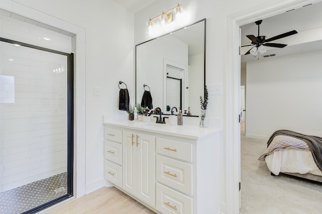 bathroom featuring a shower with door, vanity, wood-type flooring, and ceiling fan