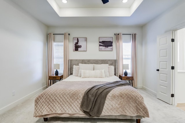 carpeted bedroom with a tray ceiling