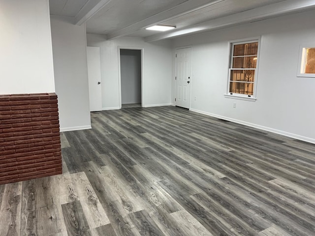 spare room with beamed ceiling and dark hardwood / wood-style flooring