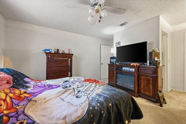 carpeted bedroom with ceiling fan and a textured ceiling