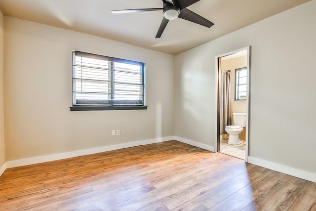 unfurnished bedroom with ceiling fan, ensuite bathroom, and light hardwood / wood-style floors