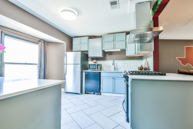 kitchen featuring ventilation hood, sink, backsplash, and stainless steel appliances