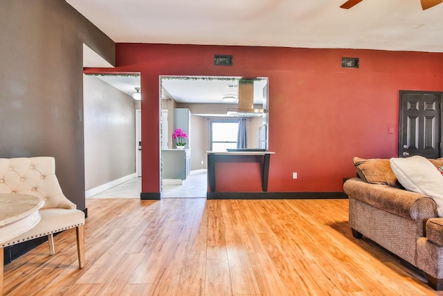 living room featuring ceiling fan and light hardwood / wood-style flooring