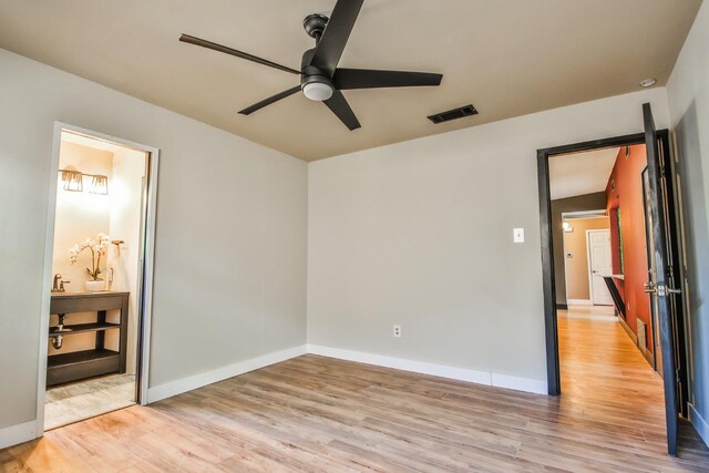 unfurnished bedroom featuring ceiling fan, ensuite bathroom, and light hardwood / wood-style floors