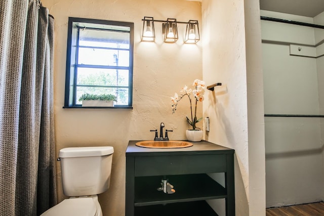 bathroom featuring wood-type flooring, toilet, a shower with shower curtain, and vanity