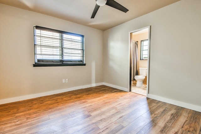 unfurnished bedroom featuring ceiling fan, ensuite bathroom, and light hardwood / wood-style floors