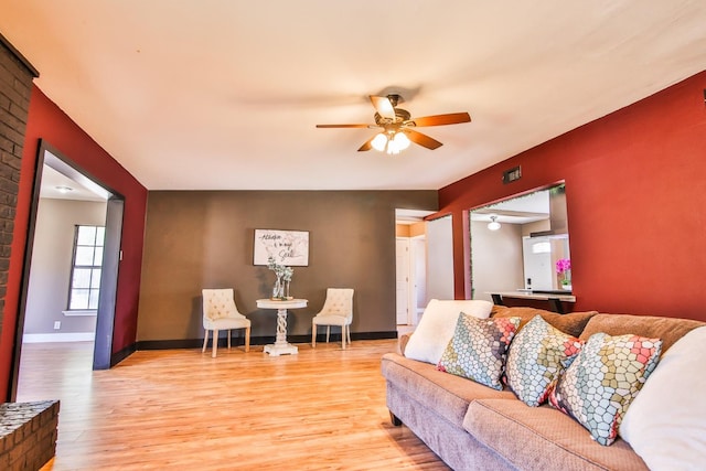 living room with ceiling fan and light hardwood / wood-style flooring