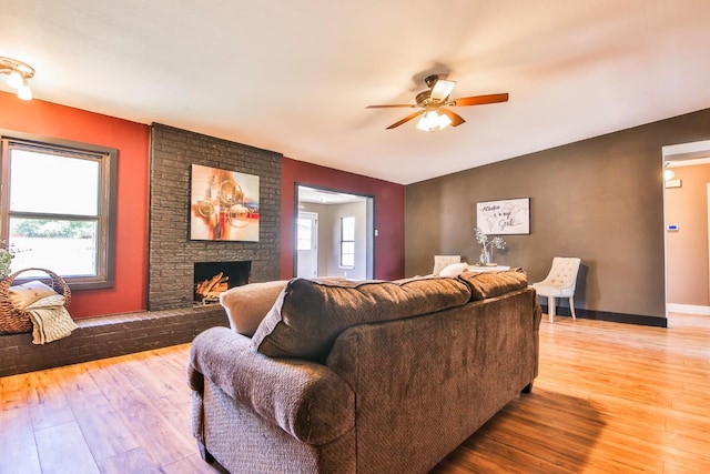 living room featuring a healthy amount of sunlight, light wood-type flooring, and a fireplace