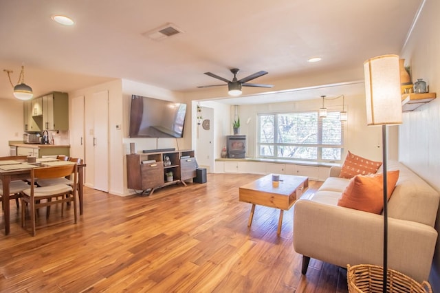 living room with light hardwood / wood-style flooring and ceiling fan