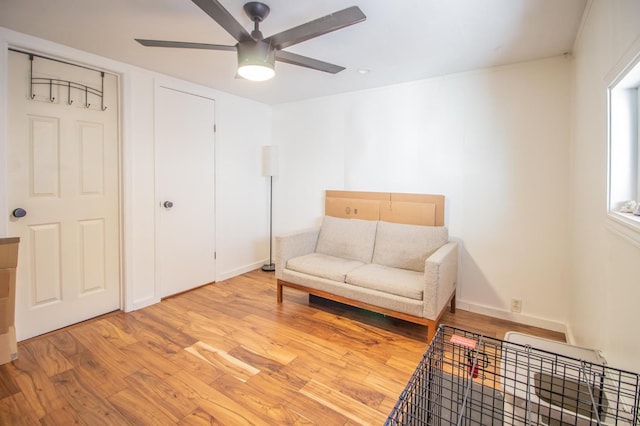 living area with ceiling fan and light hardwood / wood-style floors