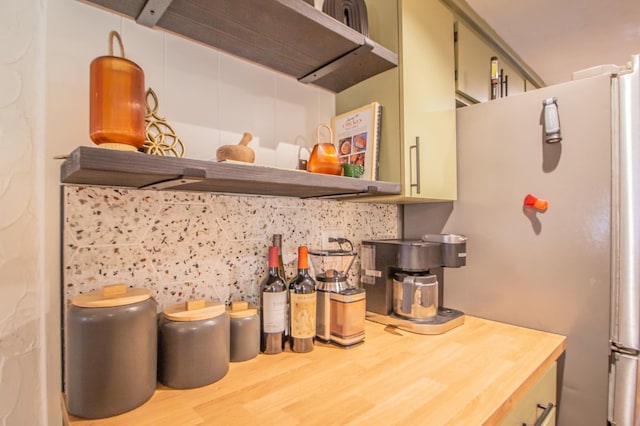 kitchen with extractor fan, wood-type flooring, decorative backsplash, fridge, and green cabinetry