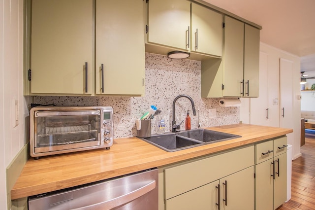 kitchen featuring wood counters, sink, tasteful backsplash, light hardwood / wood-style flooring, and stainless steel dishwasher