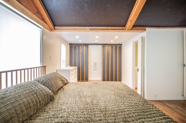 bedroom featuring beamed ceiling and hardwood / wood-style floors