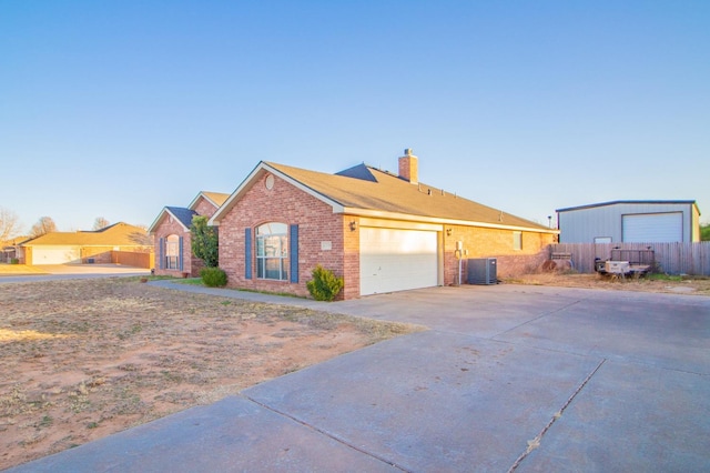 single story home featuring cooling unit and a garage