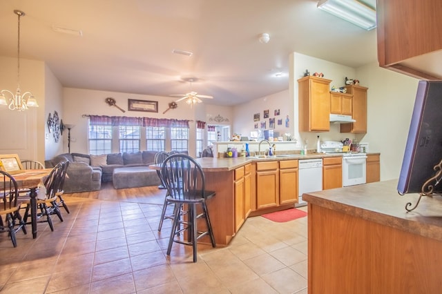 kitchen featuring light tile patterned floors, white appliances, ceiling fan with notable chandelier, and hanging light fixtures