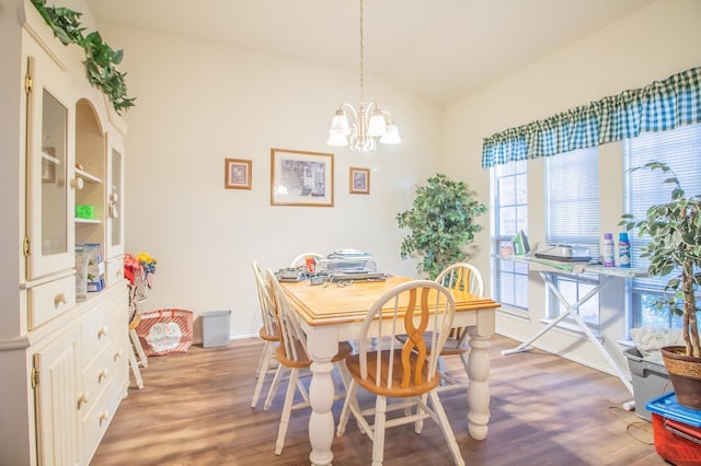 dining room featuring lofted ceiling, hardwood / wood-style floors, and a chandelier