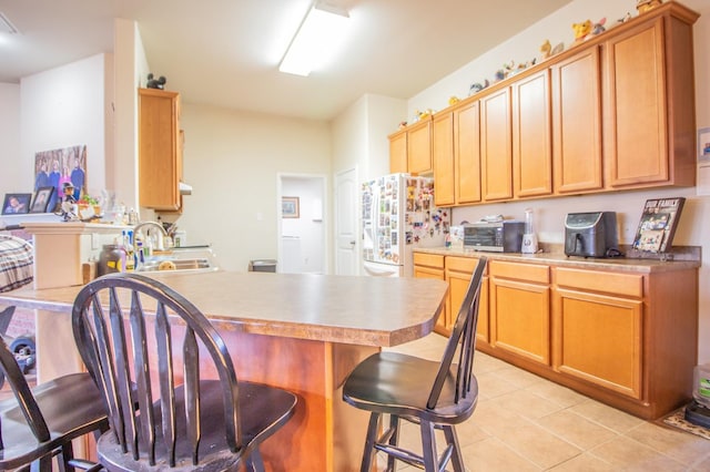 kitchen featuring sink, white fridge, and light tile patterned floors