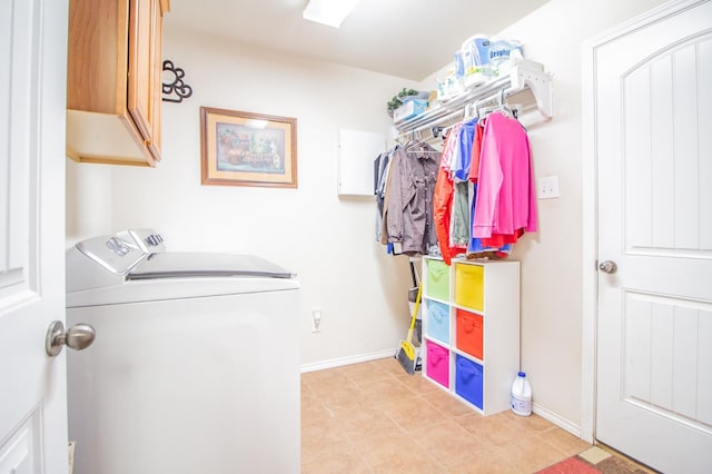 clothes washing area featuring cabinets and washer and dryer