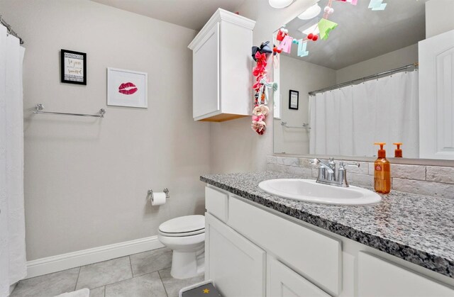 bathroom with tile patterned flooring, vanity, and toilet