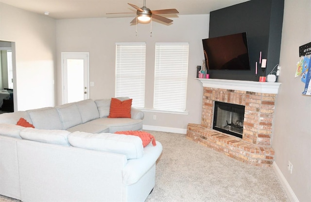 living room featuring a fireplace, light colored carpet, and ceiling fan