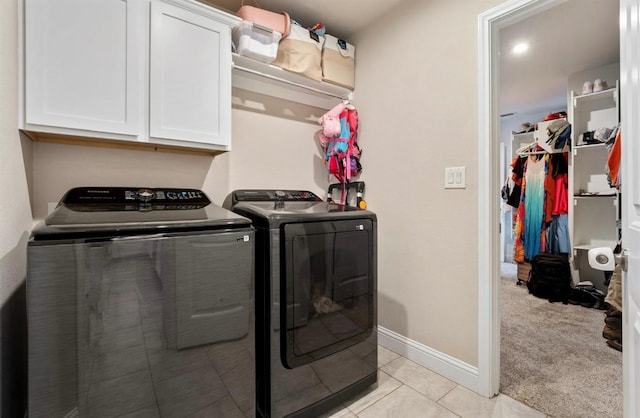 washroom featuring cabinets, separate washer and dryer, and light carpet