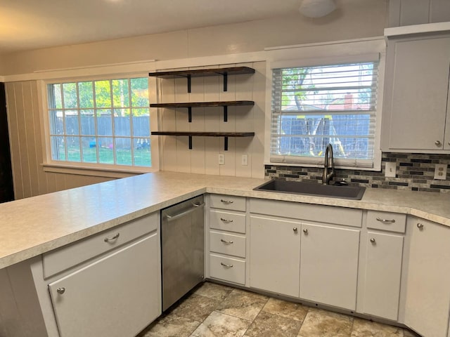 kitchen with tasteful backsplash, sink, white cabinets, and dishwasher