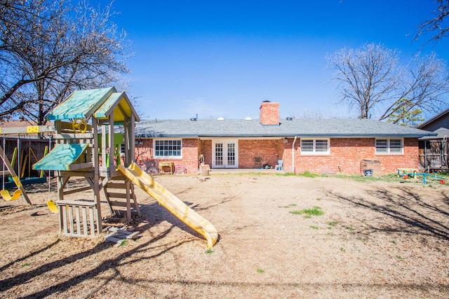 rear view of property with french doors and a playground