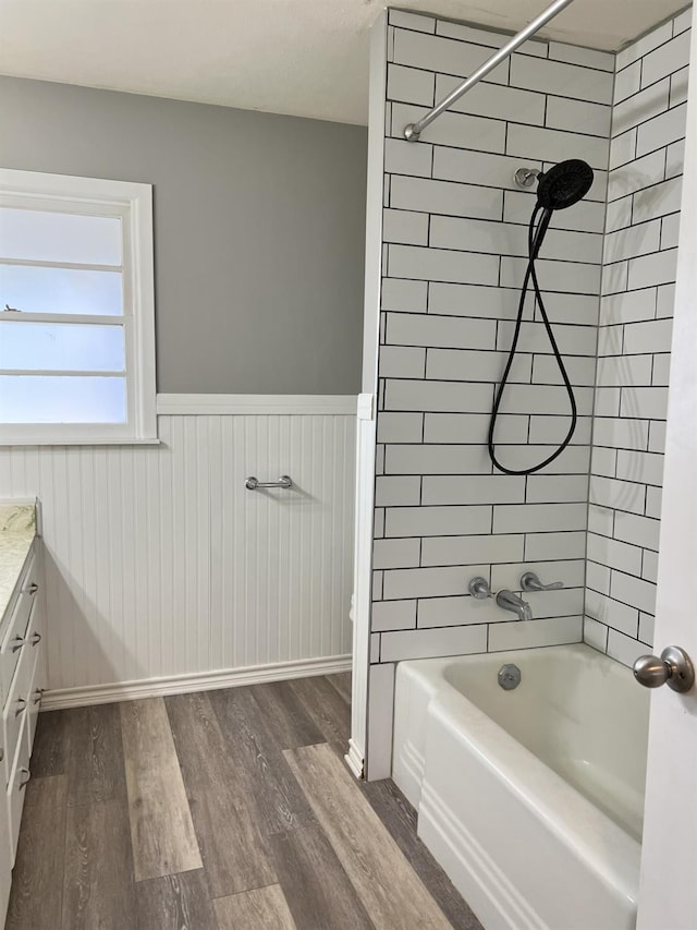 bathroom featuring hardwood / wood-style flooring, vanity, and tiled shower / bath combo