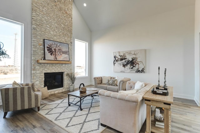 living room with hardwood / wood-style flooring, a fireplace, and high vaulted ceiling