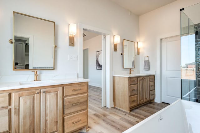 bathroom featuring vanity, hardwood / wood-style floors, and a tub