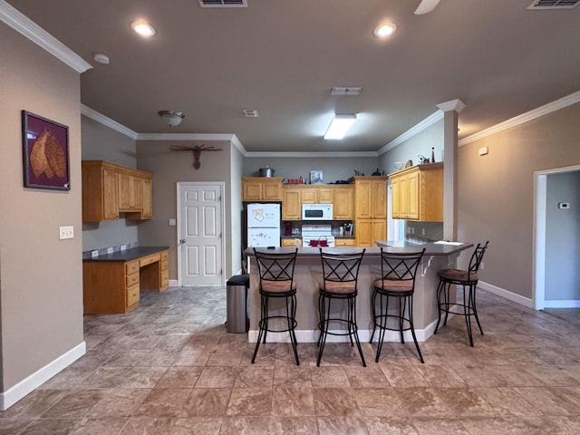 kitchen featuring a breakfast bar, crown molding, white appliances, built in desk, and ceiling fan