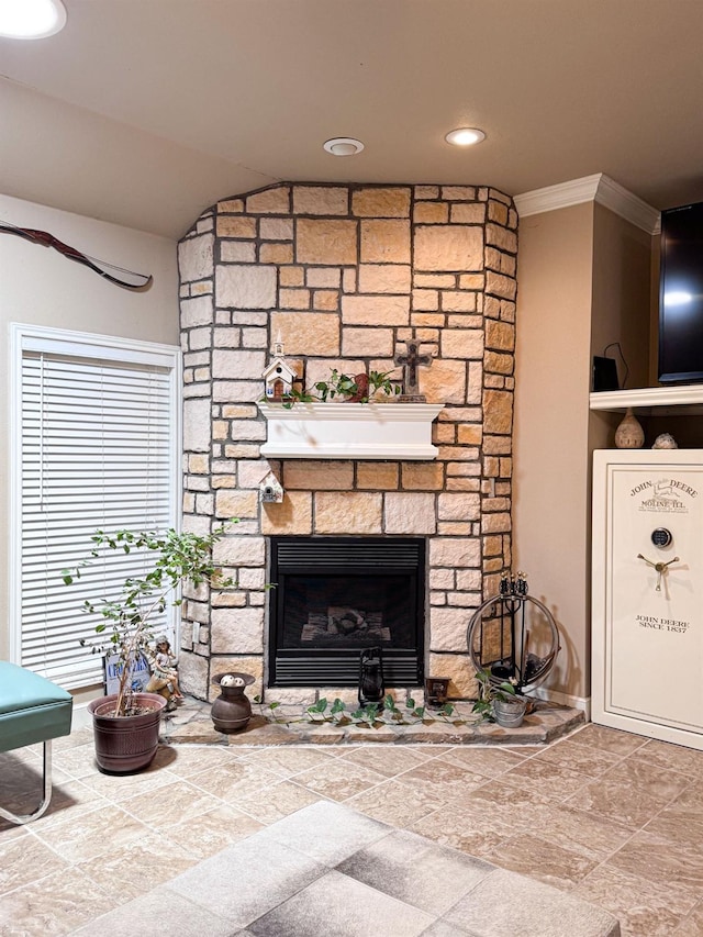 interior details with ornamental molding and a stone fireplace