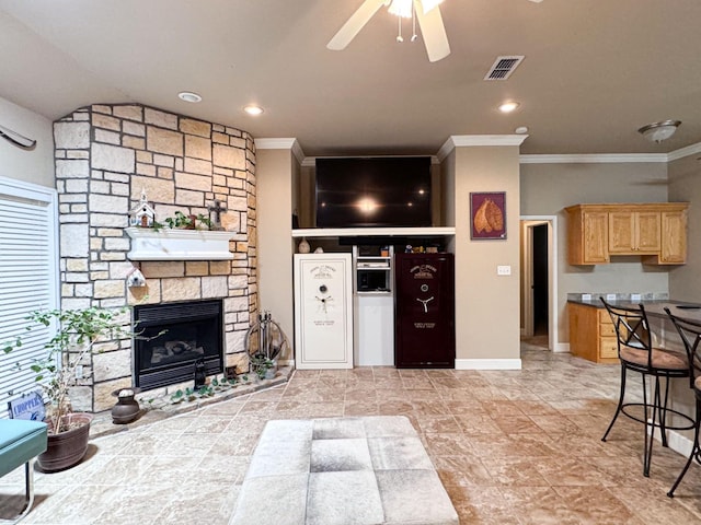 living room featuring crown molding, a fireplace, and ceiling fan