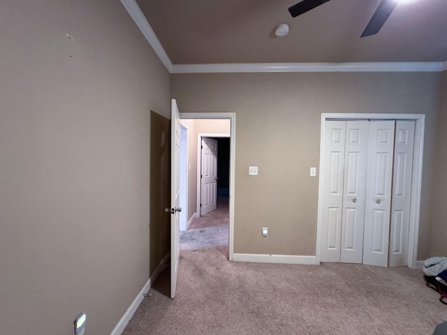 unfurnished bedroom featuring light carpet, crown molding, a closet, and ceiling fan