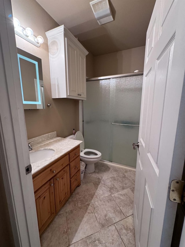 bathroom featuring an enclosed shower, vanity, and toilet