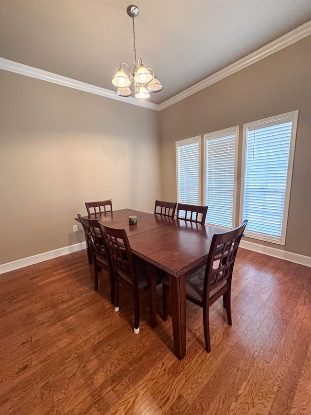 dining room featuring dark wood-type flooring, crown molding, and a chandelier