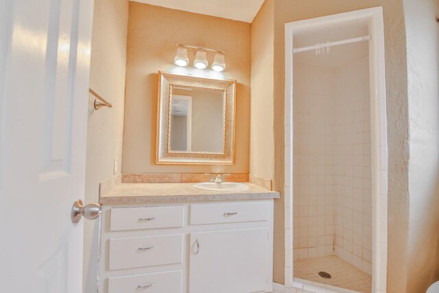 bathroom with vanity and tiled shower